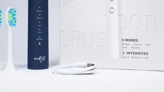 SmartClean Pro Eclatys bleue avec son câble de recharge blanc devant le coffret.