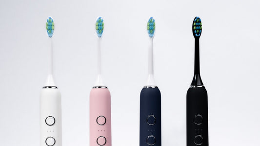 Quatre brosses à dents soniques SmartClean Pro Eclatys, ivoire, rose, bleue et noire, alignées sur fond clair.